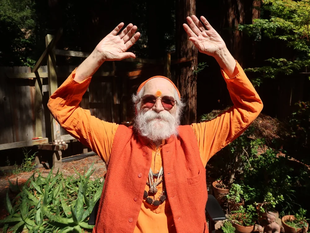 Goa Gil with both hands raised in blessing